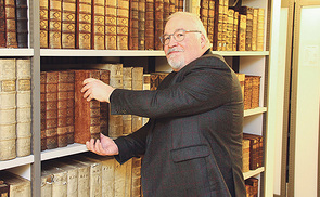 Ingo Glückler demonstriert, wie man ein Buch richtig aus dem Regal nimmt.